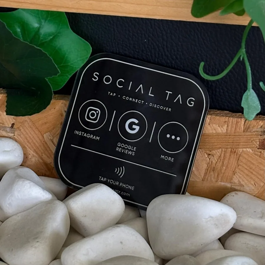 Bitki ve taşlarla süslenmiş vitrin düzeninde SocialTag etiketi